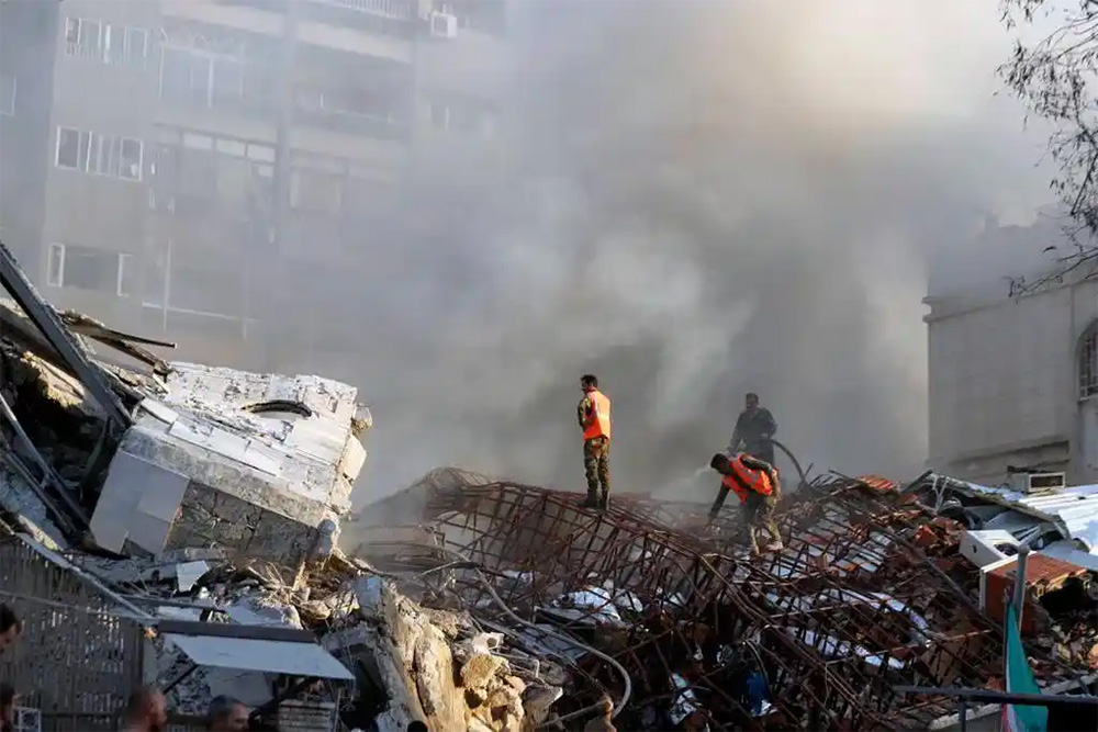 Emergency services work at a destroyed building hit by a suspected Israeli air strike in Damascus, Syria, on April 1. (Omar Sanadiki/AP)