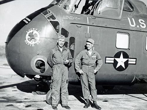 Two soldiers next to H-19 Chickasaw helicopter.