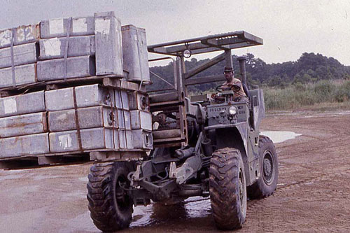 Rough Terrain Forklift in the process of loading a pallet.