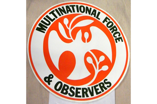 A vehicle decal used to identify vehicles assigned to the Multi-National Force and Observers (MFO), an international peacekeeping mission operating on the Sinai peninsula between Egypt and Israel. Part of the artifact  collection of the U.S. Army Transportation Museum.